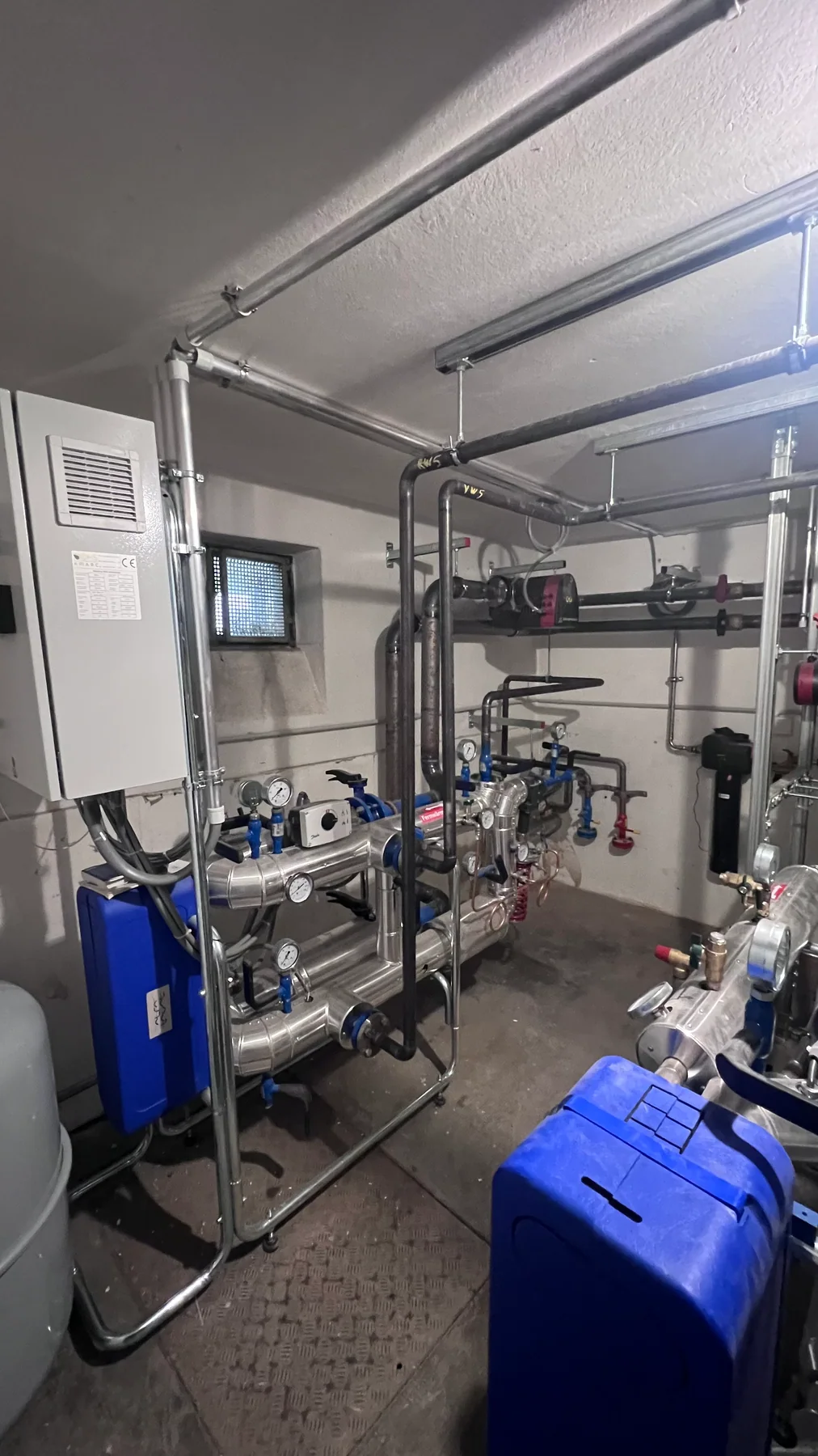 Reale Detailaufnahme der ausgeführten Fernwärme-Systemtechnik mit Rohrleitungen und Armaturen