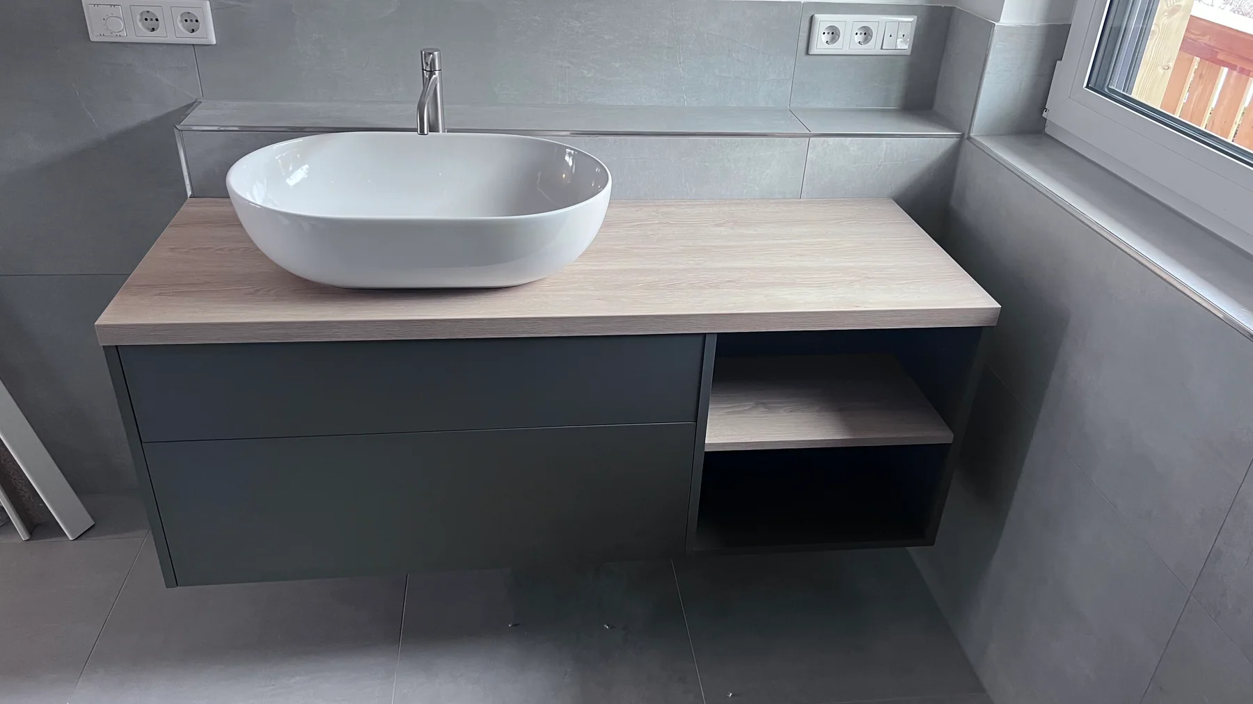 Reale Projektaufnahme eines fertig ausgeführten Waschplatzes mit Aufsatzbecken und maßgefertigtem Unterschrank